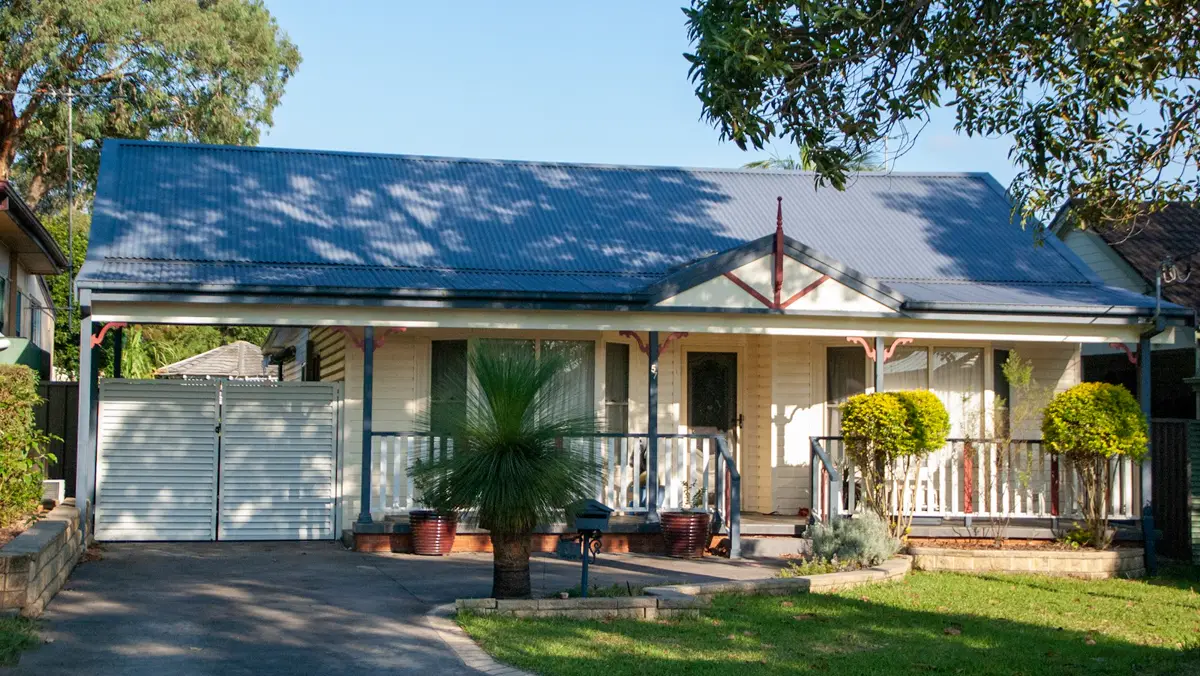 Post-war fibro house with a blue iron roof and a front verandah